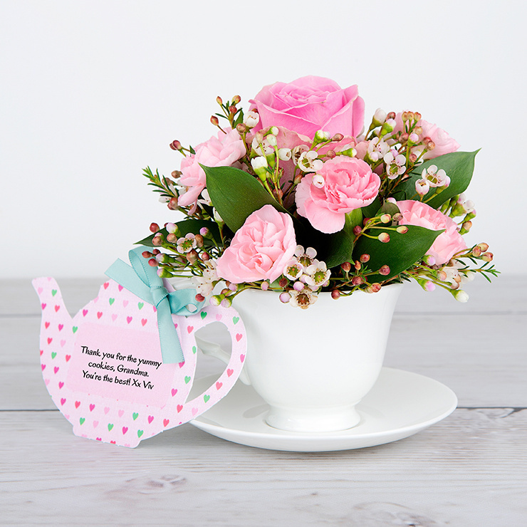 Pink Roses, Spray Carnations, White Waxflower and Dried Poppy Heads inside Bone China Teacup and Saucer image