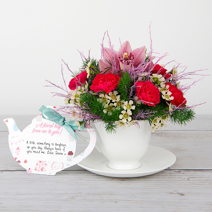 Pink Orchid, Spray Carnations, White Waxflower and Tree Fern inside Bone China Teacup image